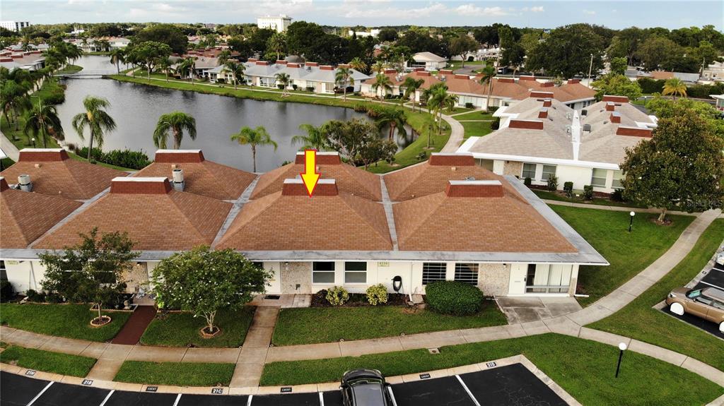An aerial view shows a single-story residential building with a brown shingled roof and chimneys — 4334 TAHITIAN GARDENS CIRCLE UNIT C, HOLIDAY, FL