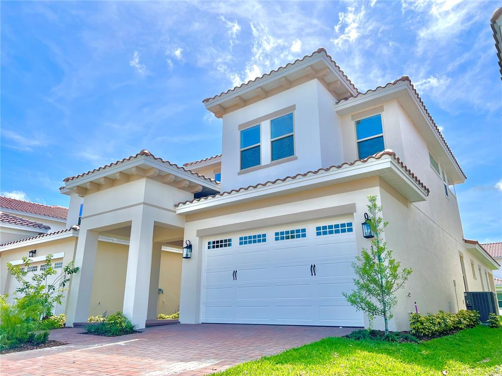 A two-story house with a white stucco exterior, a tiled roof, and a two-car garage — 13136 WEAVER AVENUE, ORLANDO, FL
