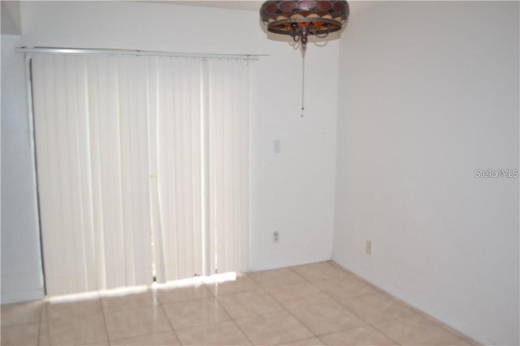 An empty dining area features light-colored floor tiles, white walls, and a hanging light fixture — 3214 RIO GRANDE TRL UNIT 00, KISSIMMEE, FL
