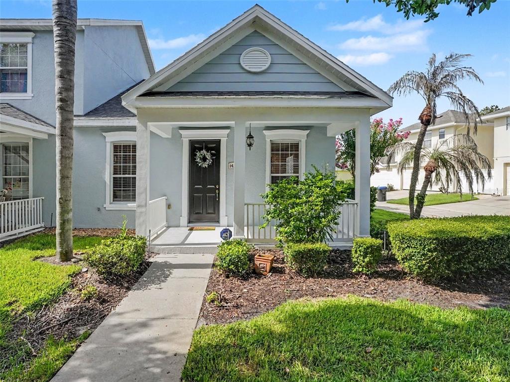 A light blue house with a front porch, a dark door, and a concrete walkway — 14250 SONCO, WINDERMERE, FL