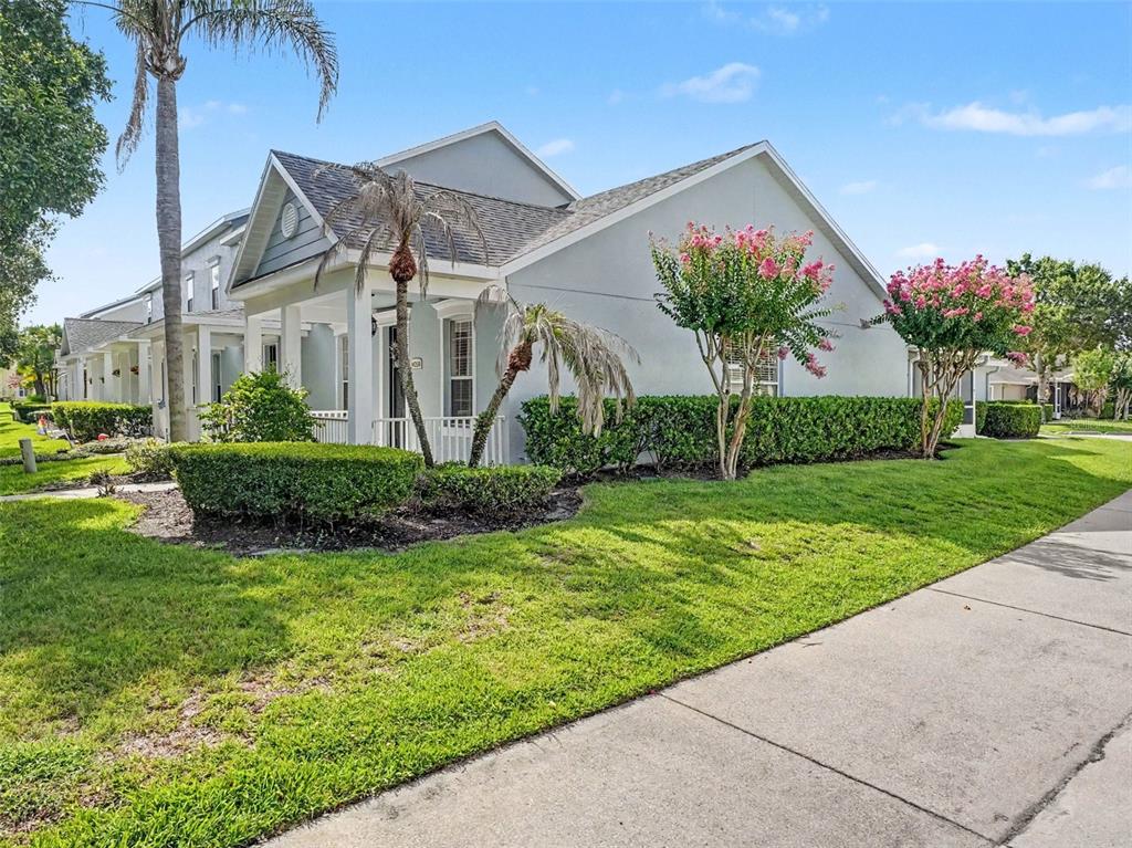 A light gray house with a covered porch, palm trees, and blooming crape myrtles — 14250 SONCO, WINDERMERE, FL