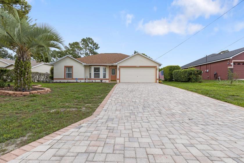 A single-story house with a paved driveway, a palm tree, and a two-car garage — 11251 PICKFORD STREET, SPRING HILL, FL