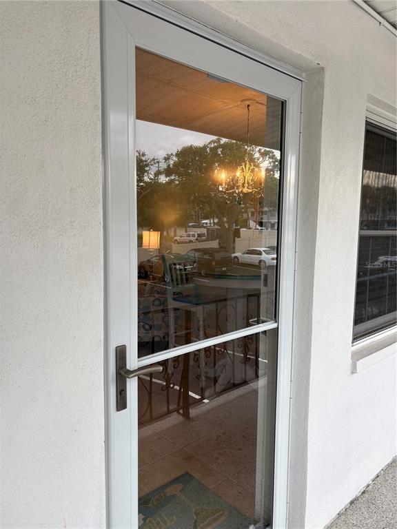 A white storm door with a glass panel and metal handle is mounted on a wall — 14531 WALSINGHAM ROAD UNIT 224, LARGO, FL
