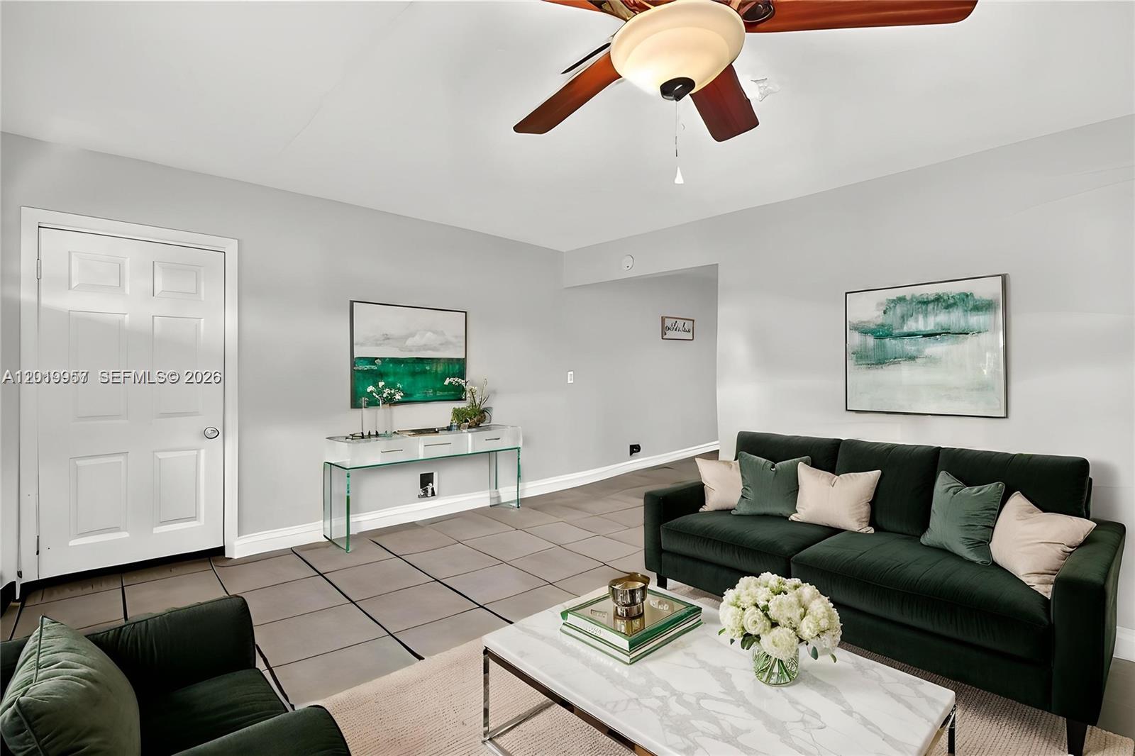 A living room features a dark green sofa, a marble coffee table, and tile flooring — 6791 Scott St, Hollywood FL 33024, HOLLYWOOD, FL