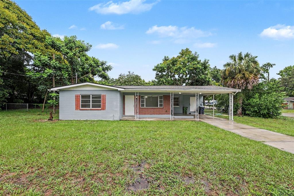A single-story house with a gray exterior, brick accents, and an attached carport — 8101 N 17TH STREET, TAMPA, FL