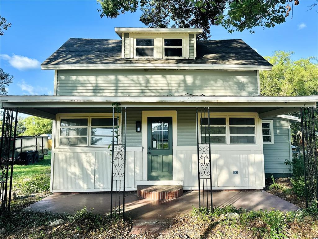 A two-story house with light green siding, a front porch, and a dormer window — 5654 12TH STREET, ZEPHYRHILLS, FL