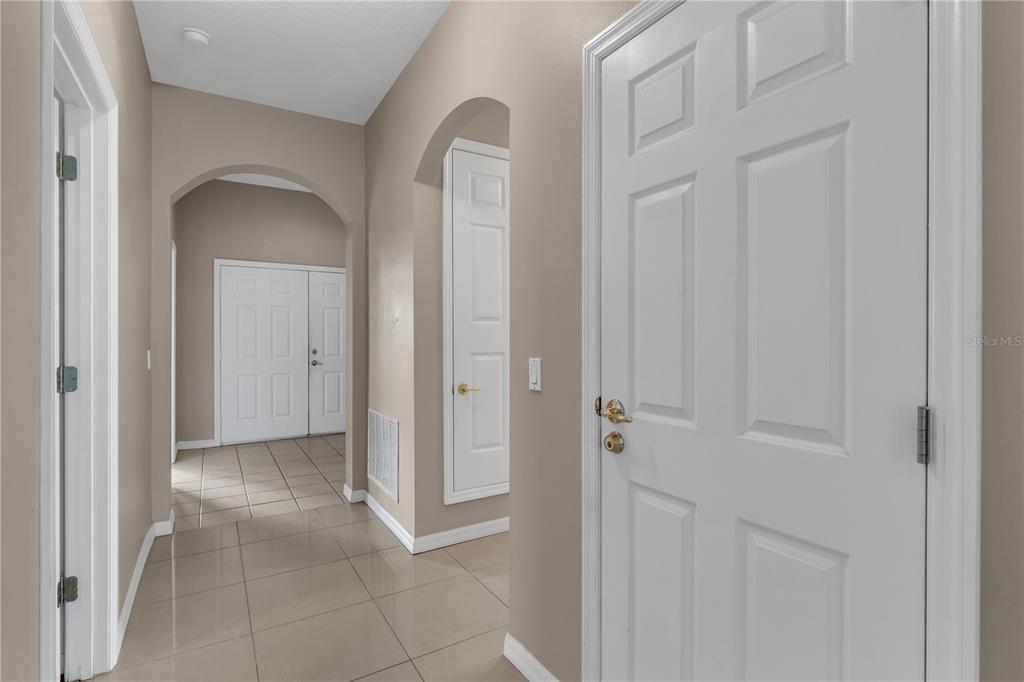 A tiled hallway features arched doorways, white trim, and several closed interior doors — 4700 CUMBRIAN LAKES DRIVE, KISSIMMEE, FL