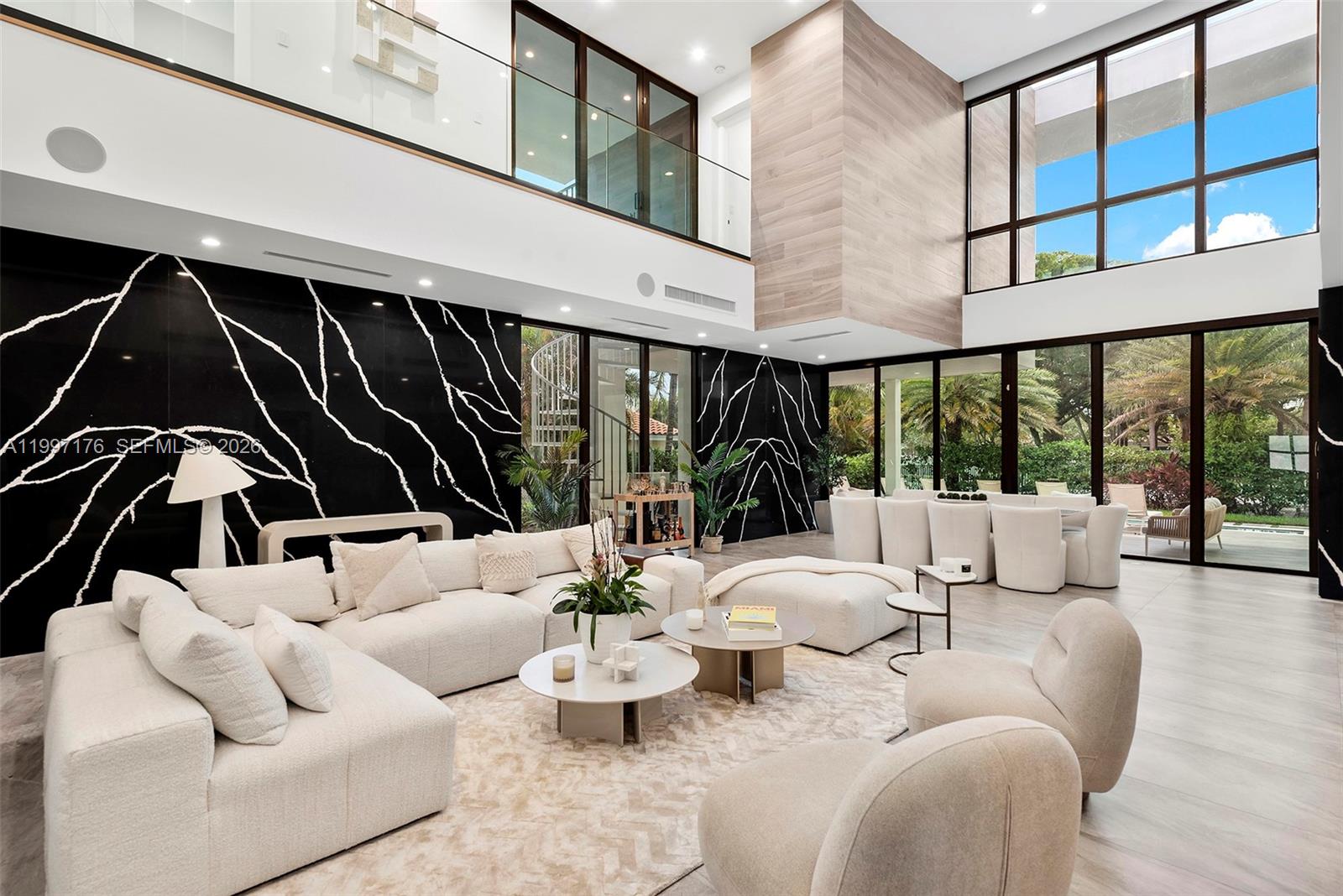 A modern living room features a double-height ceiling, black marble walls, and floor-to-ceiling windows — 521 Holiday Dr, Hallandale Beach FL 33009, HALLANDALE BEACH, FL