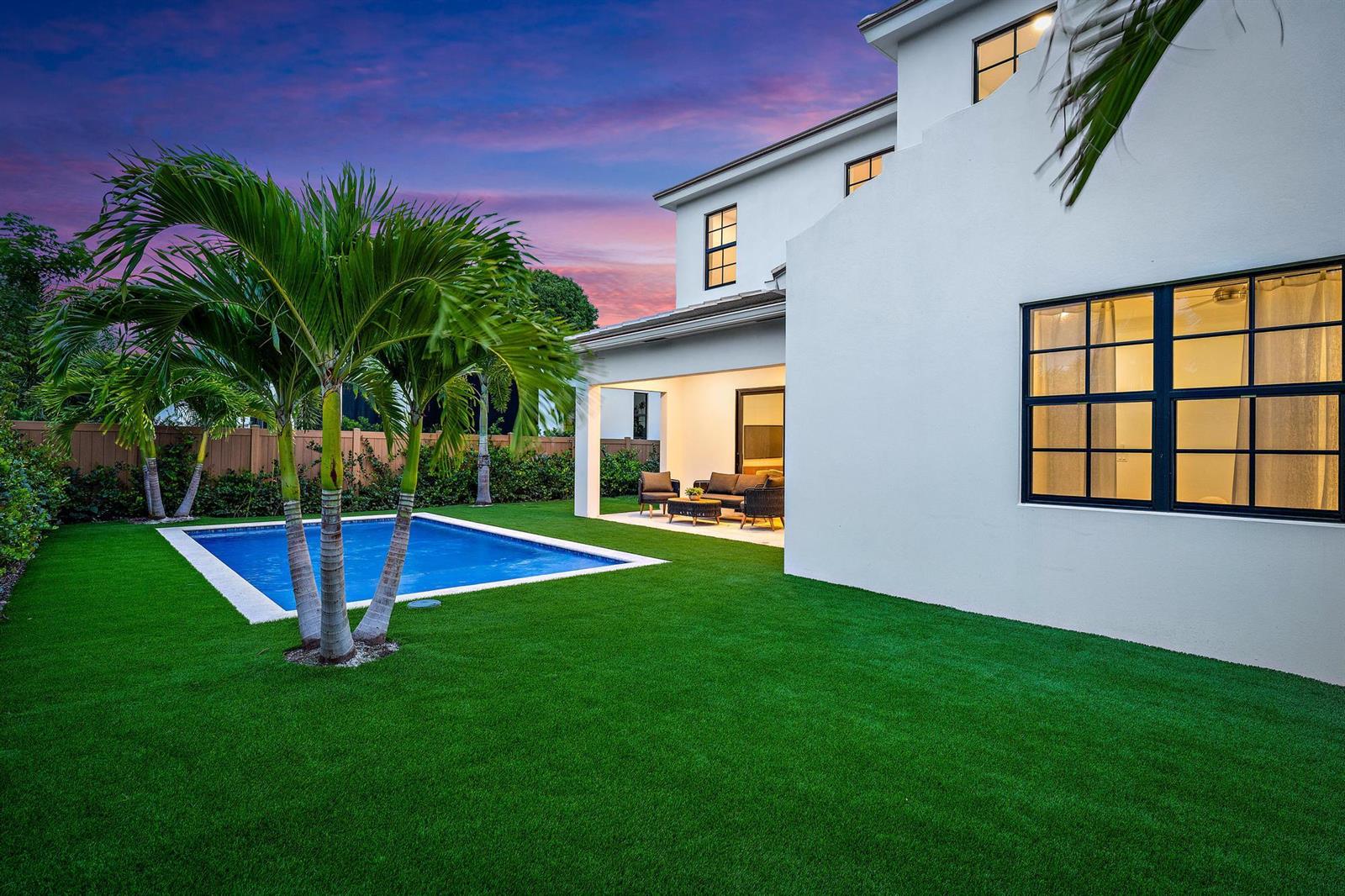 A white two-story house with a backyard pool, palm trees, and a covered patio area — 309 Cascade Lane, Palm Beach Shores FL 33404, PALM BEACH SHORES, FL
