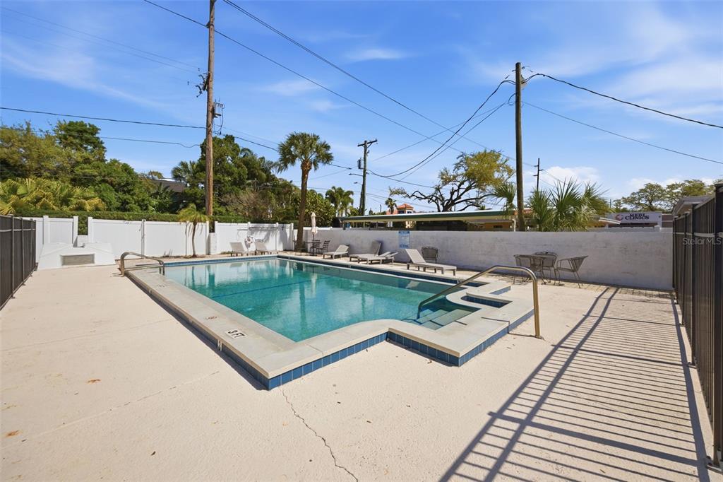 A rectangular swimming pool with a shallow entry step sits on a concrete pool deck — 3102 W HORATIO STREET UNIT 12, TAMPA, FL