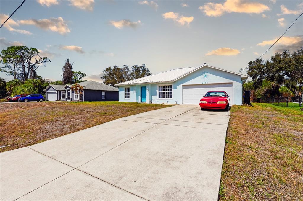 A light blue single-story house with a white roof and a concrete driveway — 4665 OAKLEY ROAD, NORTH PORT, FL
