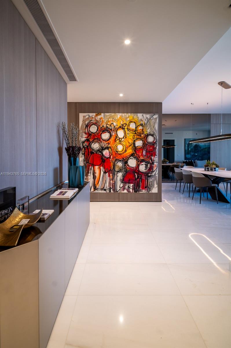 A modern hallway features a large abstract painting, a sleek console table, and white flooring — 300 Biscayne Blvd Way # 3403, Miami FL 33131, MIAMI, FL