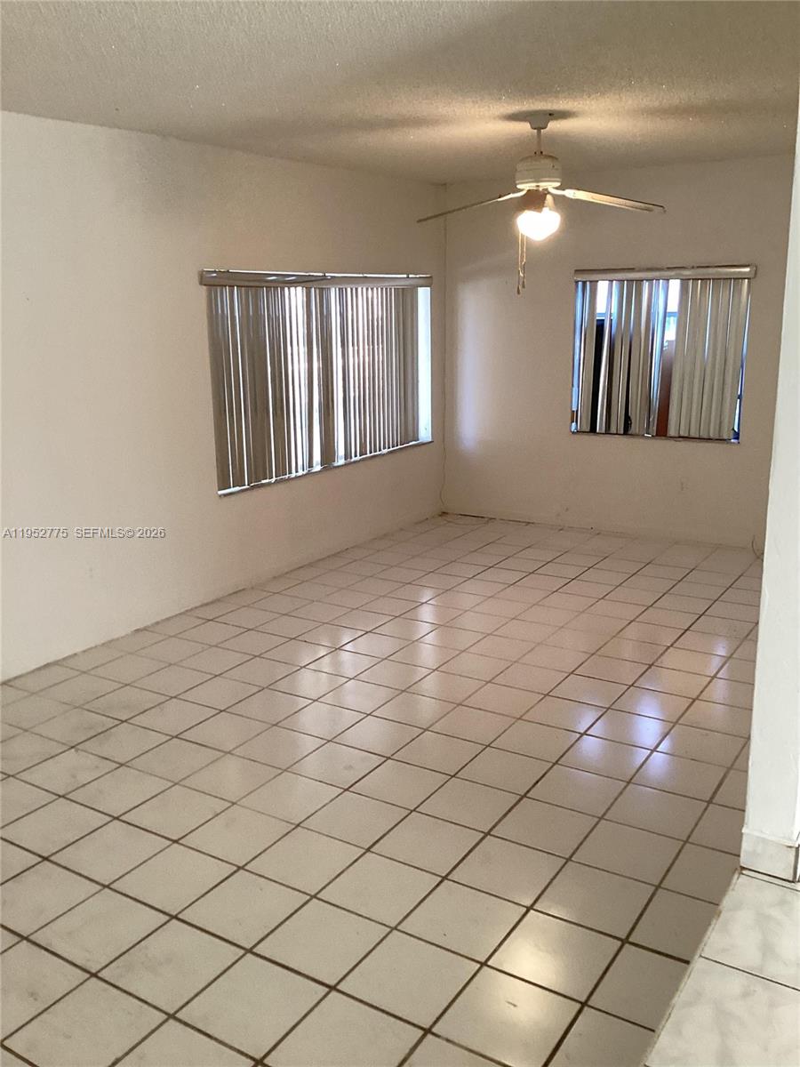 A room with white tiled floors, a ceiling fan, and windows with vertical blinds — 4824 NW 15th Ct, Miami FL 33142, MIAMI, FL
