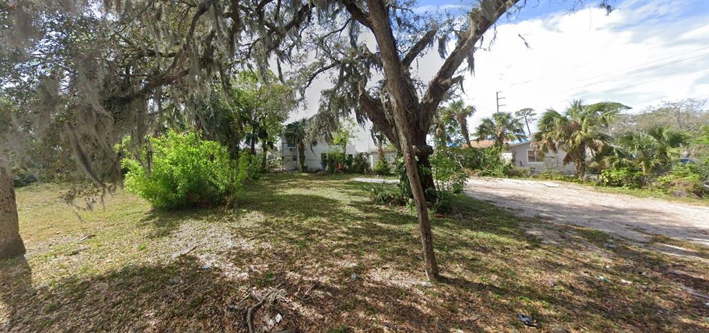 A vacant, grassy lot features large trees with Spanish moss and a gravel driveway — 358 FULTON STREET, DAYTONA BEACH, FL