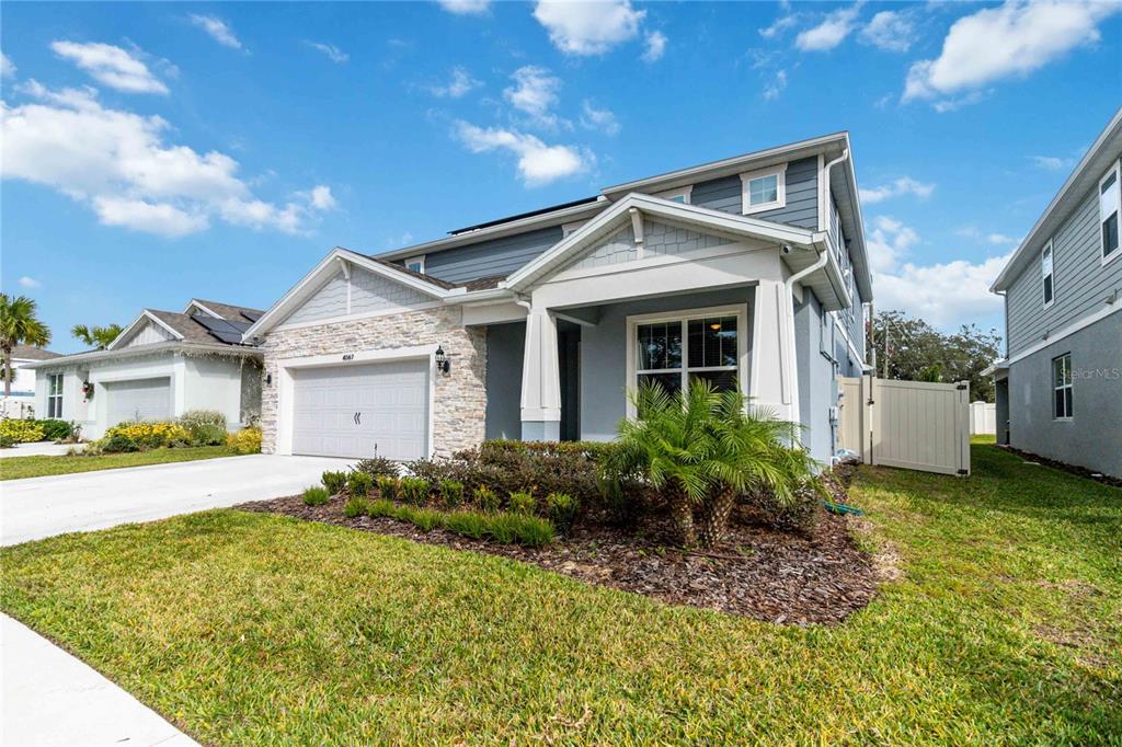 A two-story suburban house with a stone-accented garage and a front porch — 4067 MEANDERING BAY DRIVE, APOPKA, FL