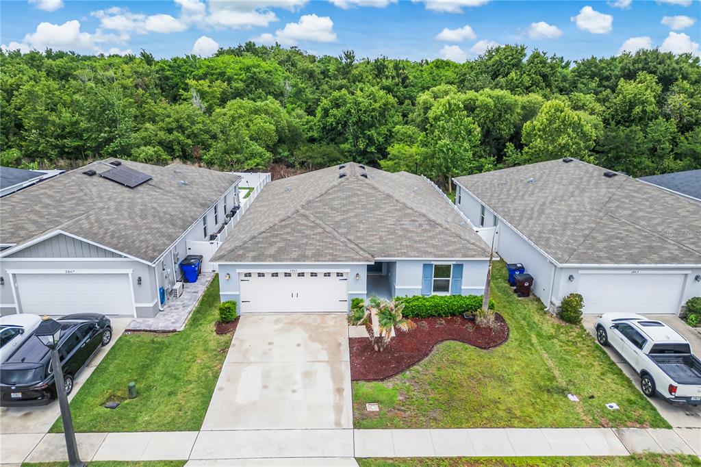 An aerial view shows a single-story house with a two-car garage and a landscaped yard — 2865 MOSSHIRE CIRCLE, ST CLOUD, FL