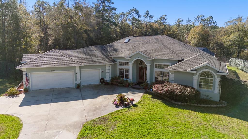 An aerial view of a single-story house with a three-car garage and a landscaped yard — 12880 SW 66TH STREET, OCALA, FL