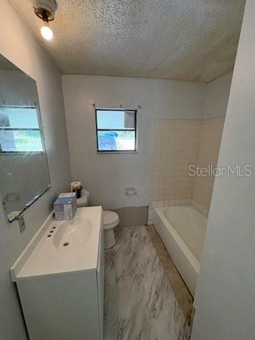 A bathroom features a white vanity, a toilet, and a bathtub with tiled walls — 2558 N COUNTY RD #470, LAKE PANASOFFKEE, FL