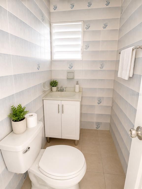A small bathroom features a white vanity, a toilet, and light blue floral-patterned wall tiles — 11 SINGAPUR, JUANA DIAZ, PR