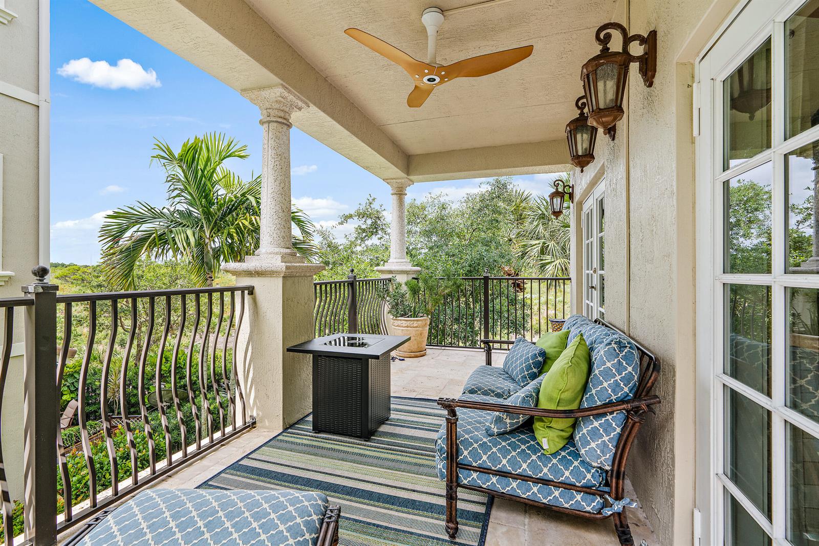 A covered balcony features a patterned sofa, a fire pit table, and a ceiling fan — 126 Tierra Lane # 4, Jupiter FL 33477, JUPITER, FL