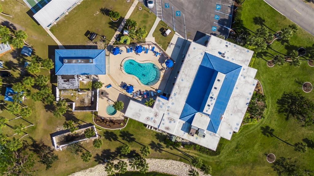 An aerial view shows a building complex with a swimming pool, spa, and parking lot — 620 CERVINA DRIVE S, VENICE, FL