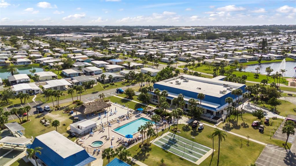 An aerial view shows a community clubhouse with a pool, tennis courts, and surrounding homes — 620 CERVINA DRIVE S, VENICE, FL