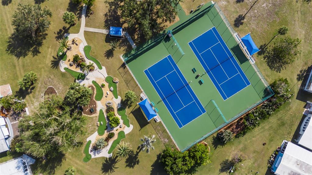 An aerial view shows two tennis courts next to a miniature golf course — 620 CERVINA DRIVE S, VENICE, FL