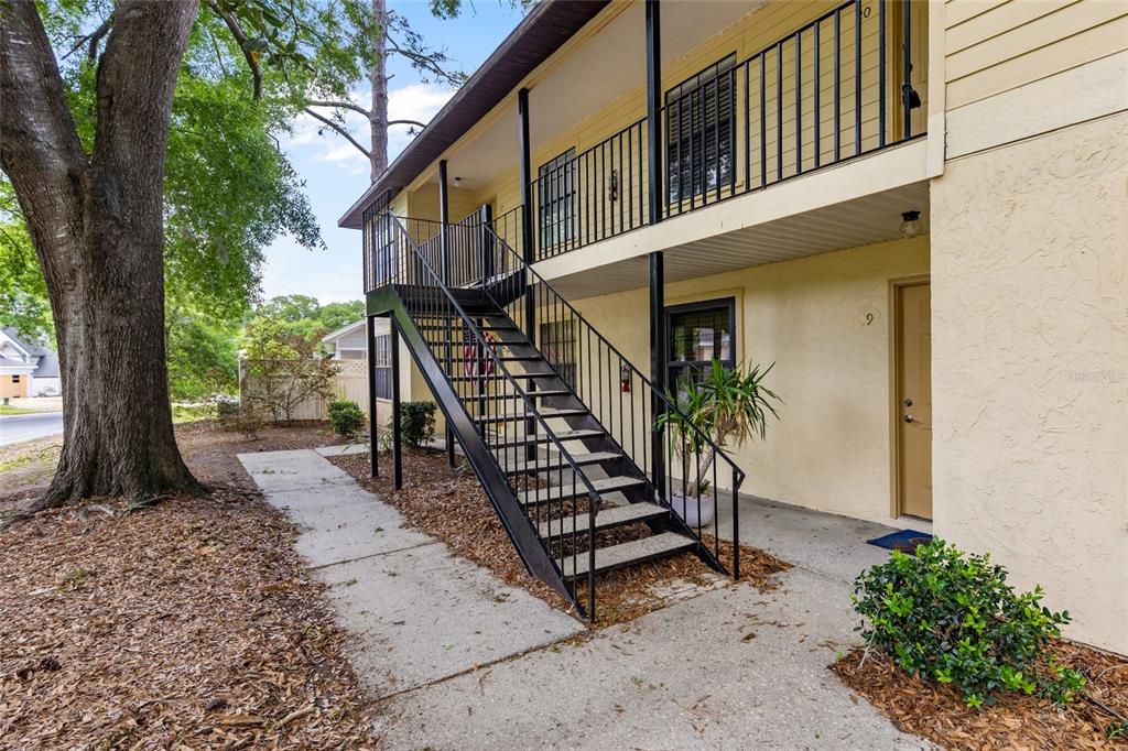 An exterior view of a two-story apartment building with metal stairs leading to the balcony — 6400 NW 106TH PLACE UNIT 20, ALACHUA, FL