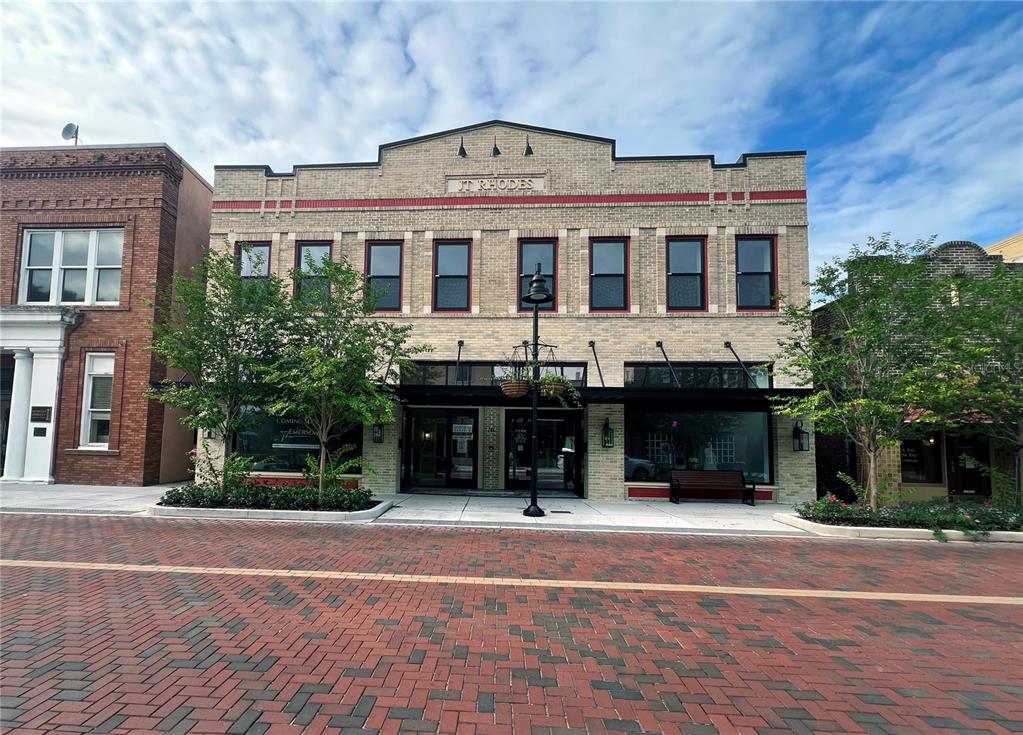 A two-story brick commercial building with a central entrance and large storefront windows — 244 E PARK AVENUE, LAKE WALES, FL