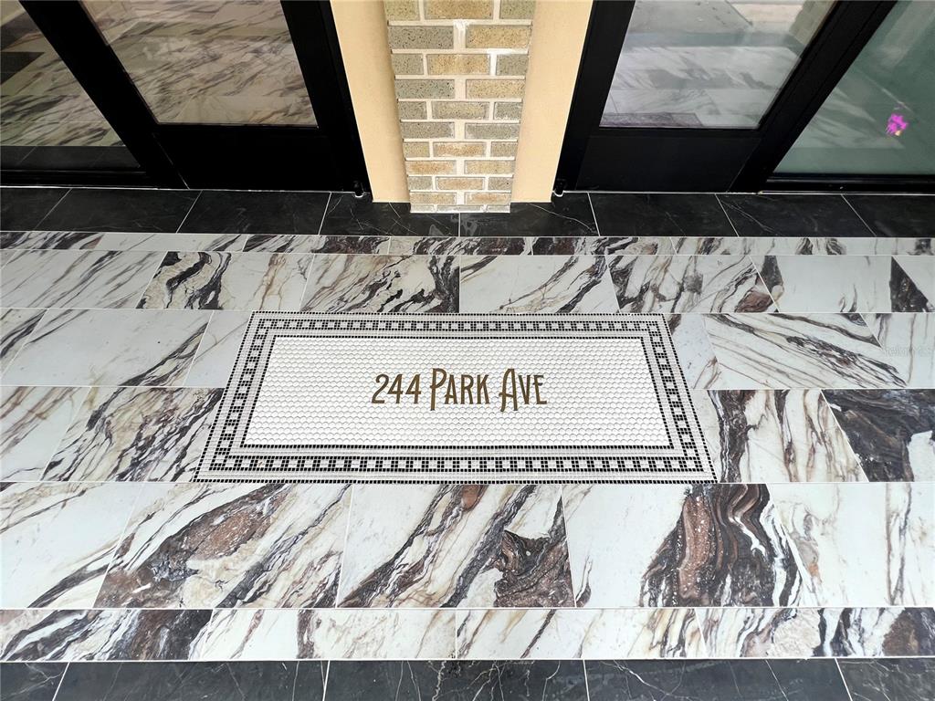 A tiled entryway features a central mosaic inlay with text surrounded by marble-patterned floor tiles — 244 E PARK AVENUE, LAKE WALES, FL