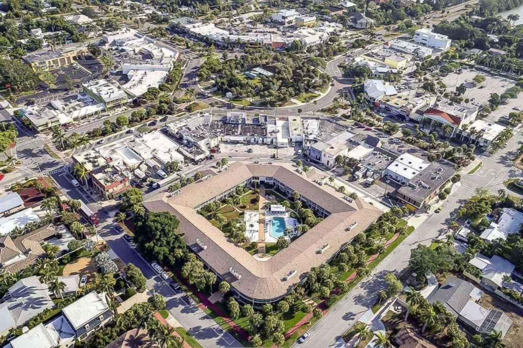 An aerial view shows a square-shaped apartment complex with a central courtyard and swimming pool — 500 S WASHINGTON DRIVE UNIT 24B, SARASOTA, FL