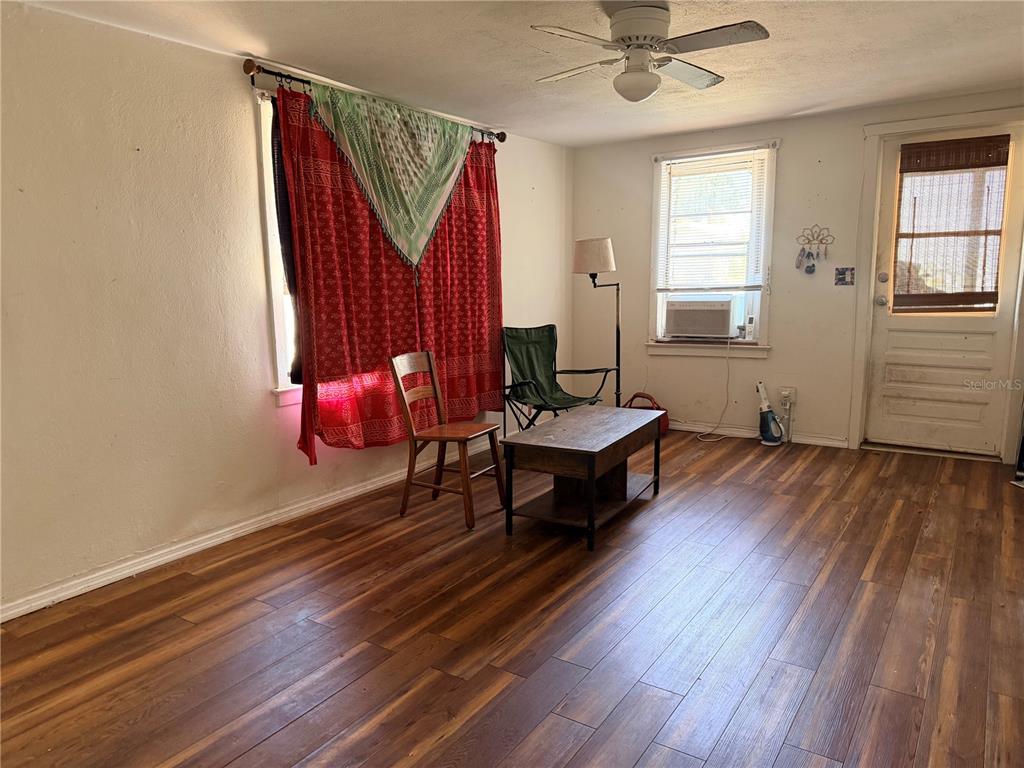 A living room features a beige sofa, striped armchair, wooden coffee table, and jute rug — 2178 7TH STREET, SARASOTA, FL