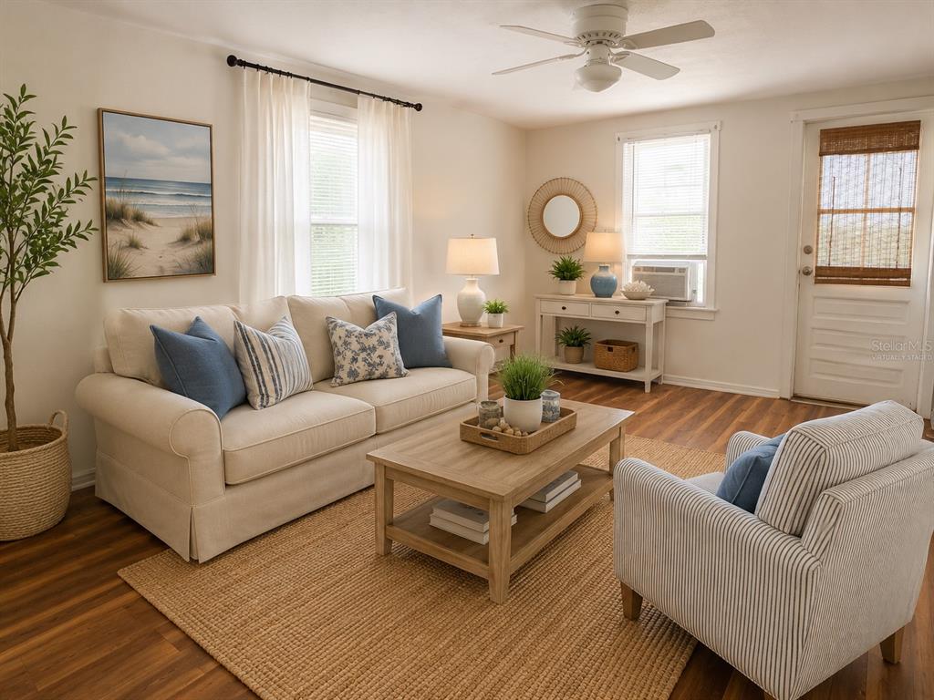 A living room features wood-look flooring, a ceiling fan, a window, and a door — 2178 7TH STREET, SARASOTA, FL