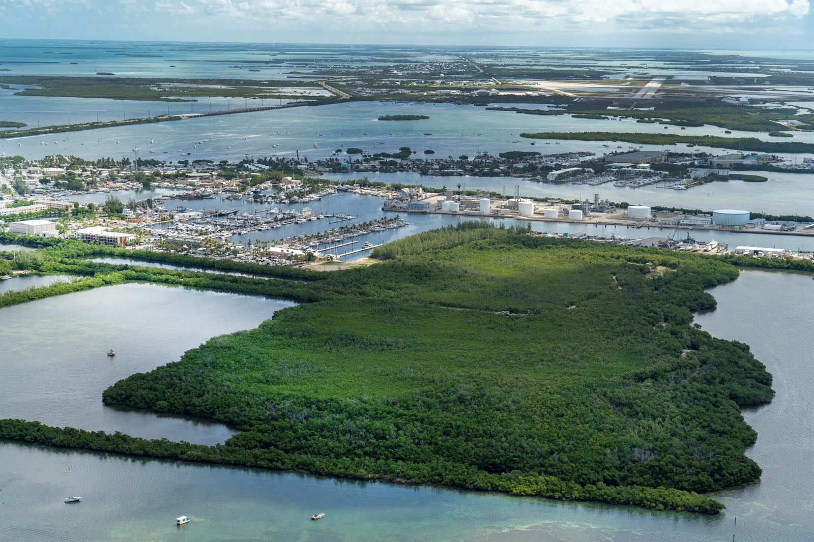 Aerial view of a coastal marina, industrial storage tanks, and a large mangrove island — 7200 5th Street, Key West FL 33040, KEY WEST, FL