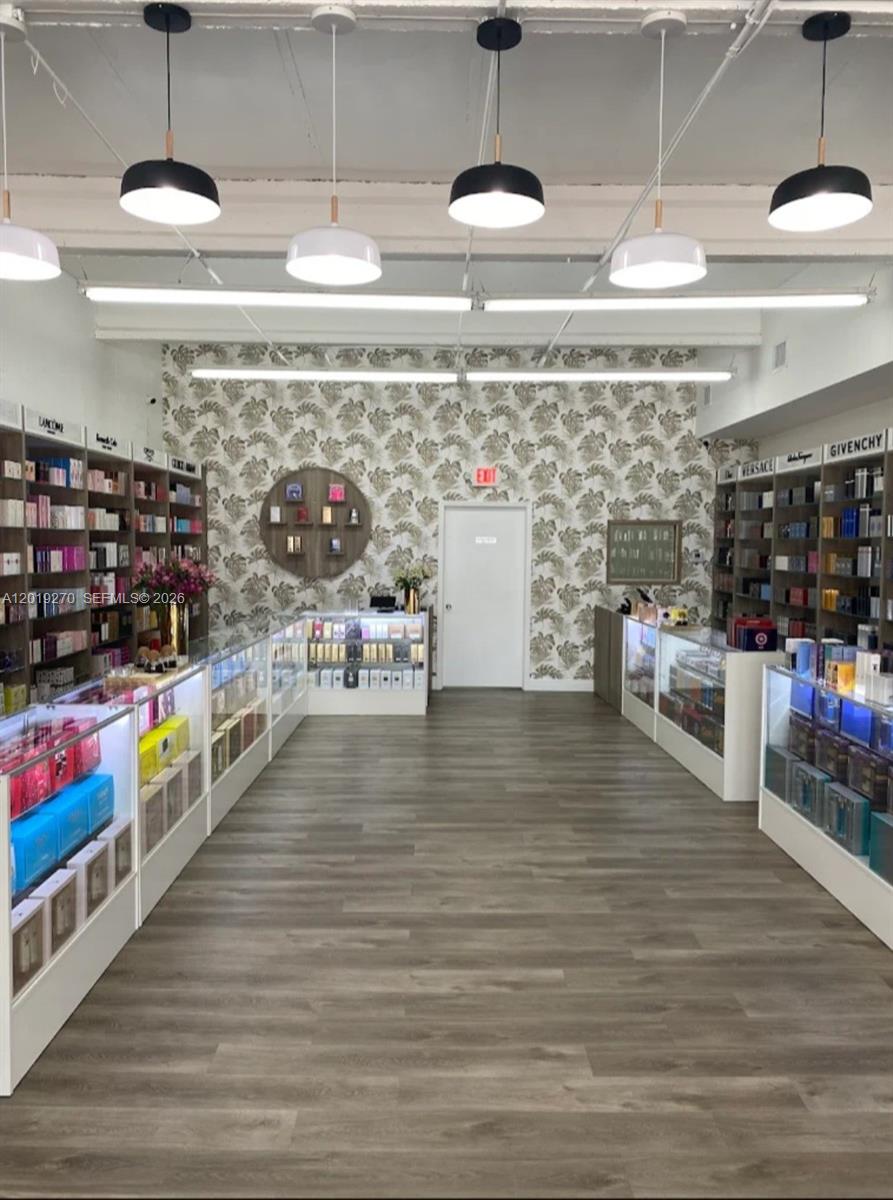 A retail perfume store features glass display cases, wall shelving, and patterned wallpaper — 1917 NW 20th St, Miami FL 33142, MIAMI, FL