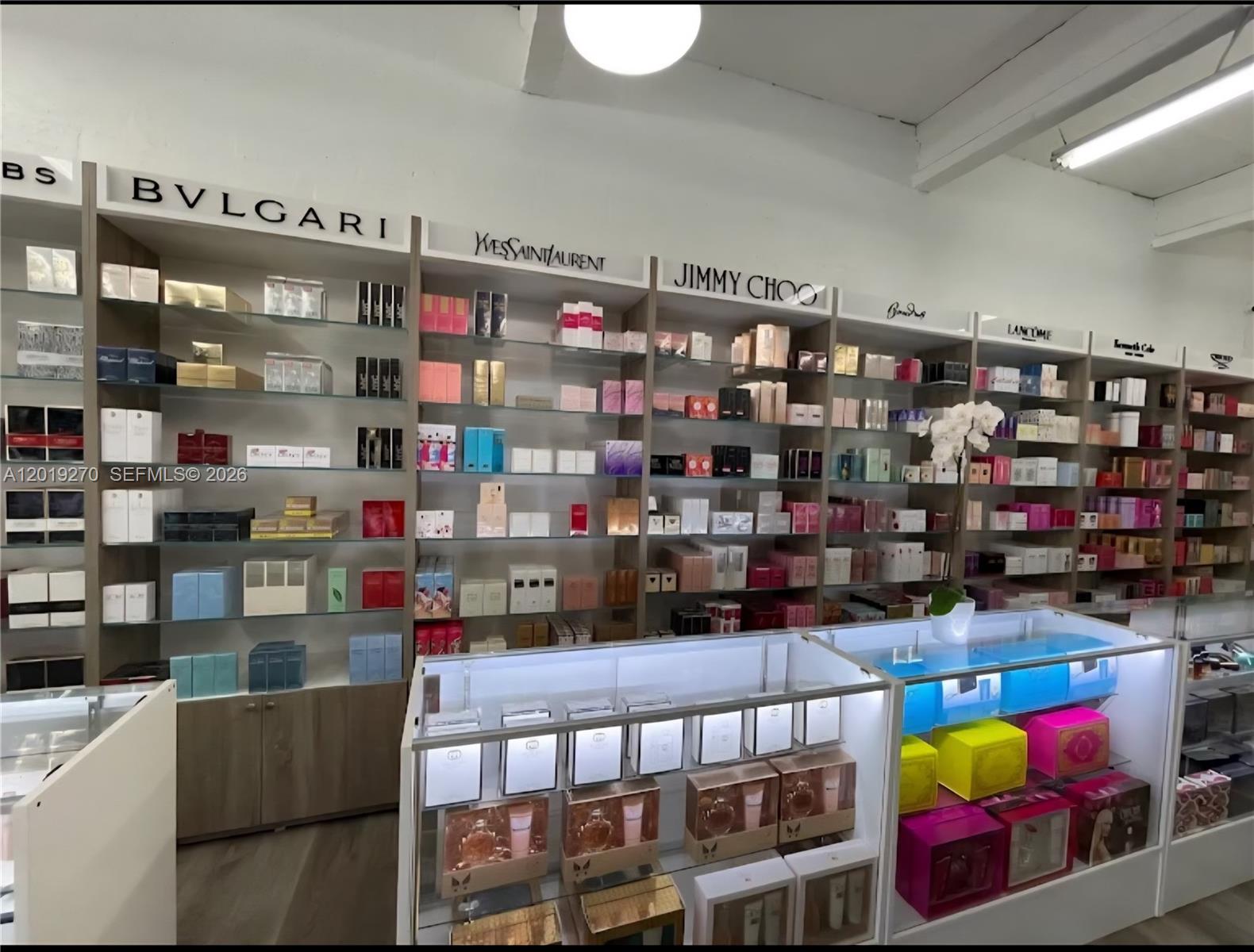 A retail store interior features shelves stocked with various perfume boxes and glass display cases — 1917 NW 20th St, Miami FL 33142, MIAMI, FL