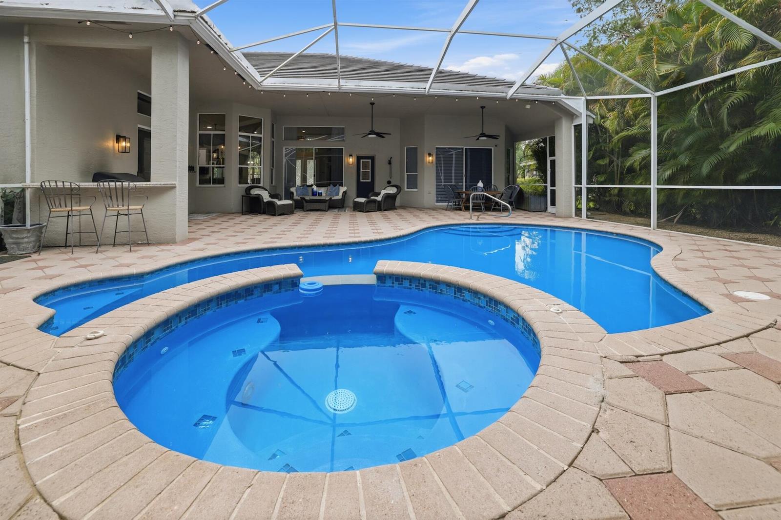 A screened-in patio features a swimming pool, a circular hot tub, and outdoor seating — 856 Forest Glen Lane, Wellington FL 33414, WELLINGTON, FL