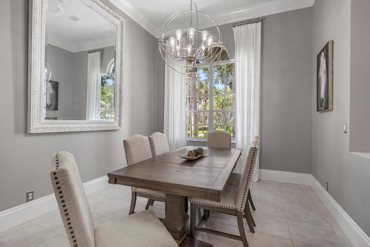 A dining room features a wooden table, upholstered chairs, a large mirror, and a chandelier — 856 Forest Glen Lane, Wellington FL 33414, WELLINGTON, FL