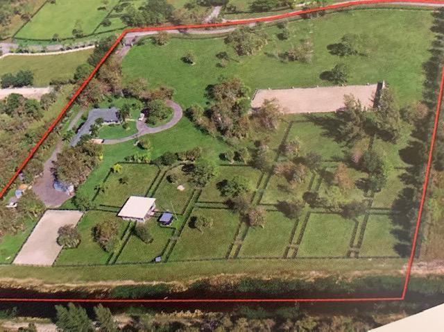 An aerial view shows a rural property with a house, outbuildings, and fenced paddocks — 2741 Buck Ridge Trail, Loxahatchee FL 33470, LOXAHATCHEE, FL