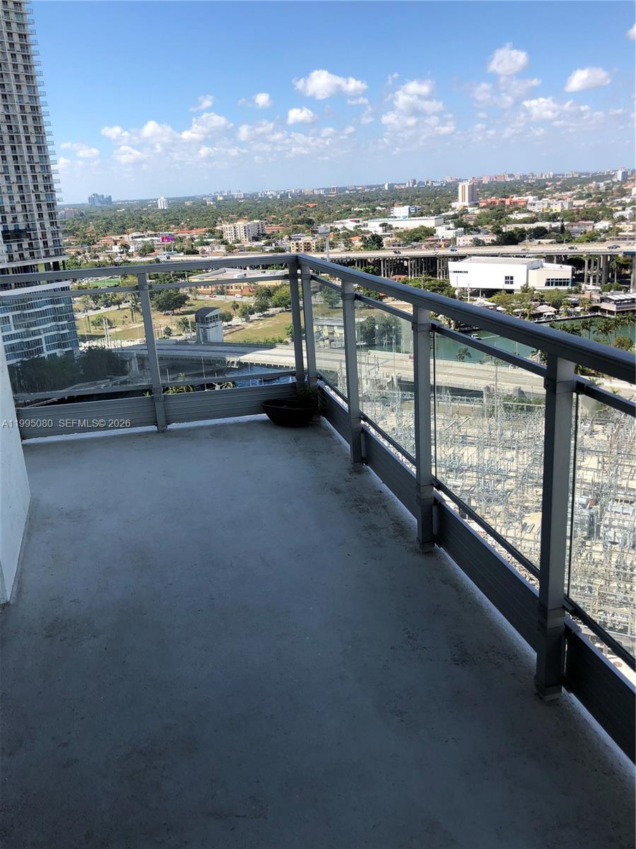 A high-rise balcony features a concrete floor, glass railings, and an expansive urban view — 90 SW 3RD STREET # 2112, Miami FL 33130, MIAMI, FL