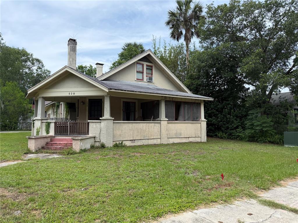 A single-story house with a front porch, stucco siding, and a gabled roof — 528 N ADELLE AVENUE, DELAND, FL