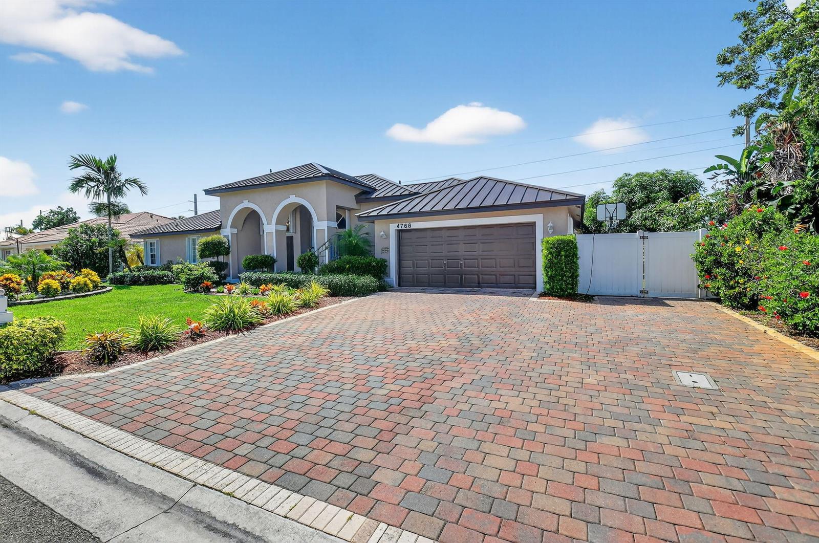 A single-story house with a brown metal roof, arched entryway, and a brick paver driveway — 4768 Cypress Drive S, Boynton Beach FL 33436, BOYNTON BEACH, FL