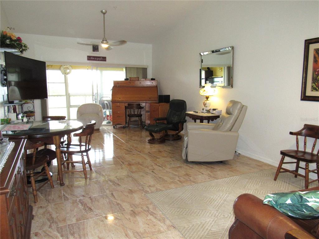 A living and dining area features tile flooring, a ceiling fan, and various furniture pieces — 175 KINGS HIGHWAY UNIT 933, PUNTA GORDA, FL