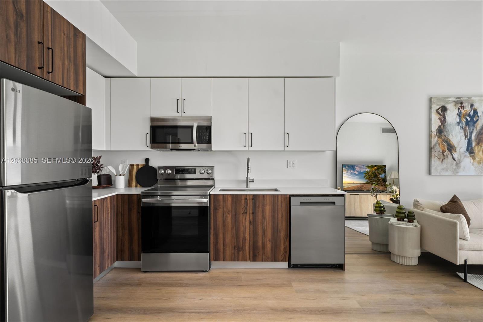 A modern kitchen features two-tone wood and white cabinetry with stainless steel appliances — 2479 NE 192nd St # 306, Miami FL 33180, MIAMI, FL