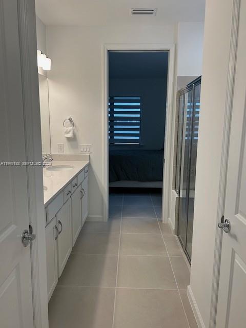 A bathroom with a white vanity, light tile flooring, and a glass-enclosed shower — 6385 Honor Way, Ave Maria FL 34142, AVE MARIA, FL