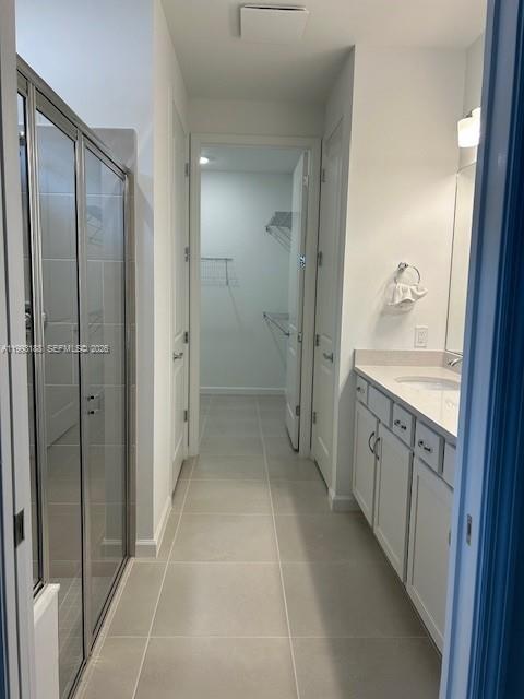A bathroom features a glass-enclosed shower, white vanity cabinets, and a doorway leading to a closet — 6385 Honor Way, Ave Maria FL 34142, AVE MARIA, FL