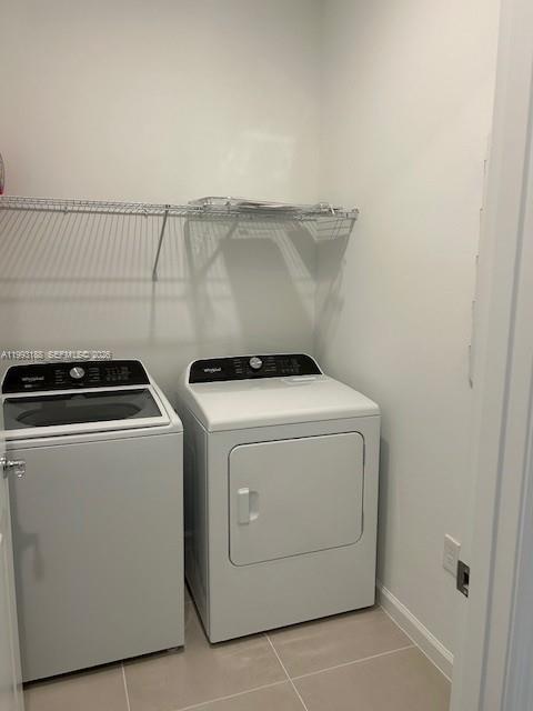 A laundry room features a white top-load washer and dryer beneath a wire shelf — 6385 Honor Way, Ave Maria FL 34142, AVE MARIA, FL