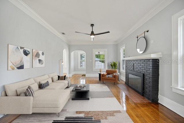 A living room features a light-colored sectional sofa, a black brick fireplace, and hardwood floors — 617 KERNEYWOOD STREET, LAKELAND, FL