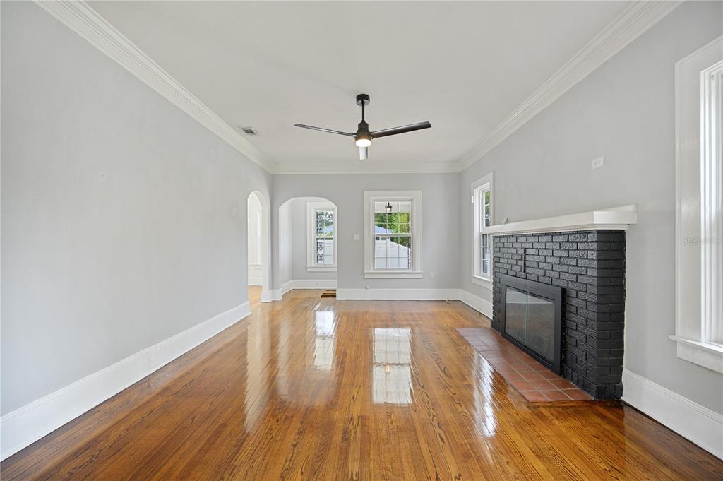 A living room features hardwood floors, a black brick fireplace, and a ceiling fan — 617 KERNEYWOOD STREET, LAKELAND, FL
