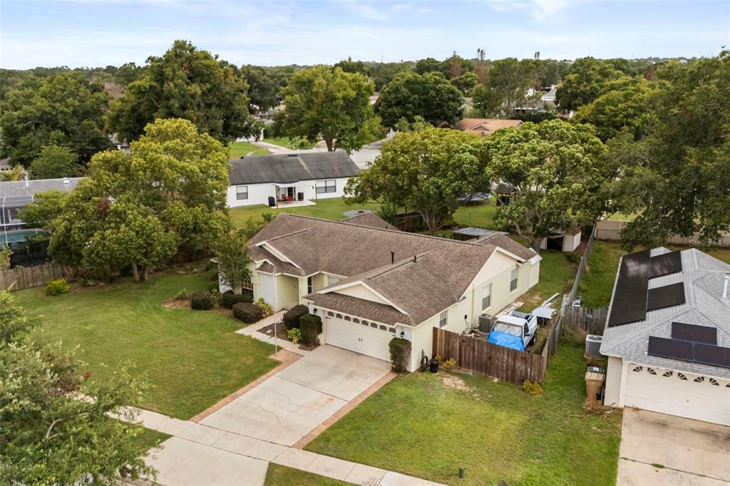 An aerial view shows a single-story house with a tan exterior and a brown roof — 14513 POINTE EAST TRAIL, CLERMONT, FL